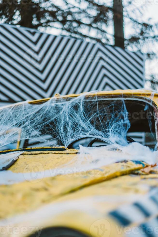 Old retro yellow taxi decorated with cobwebs photo