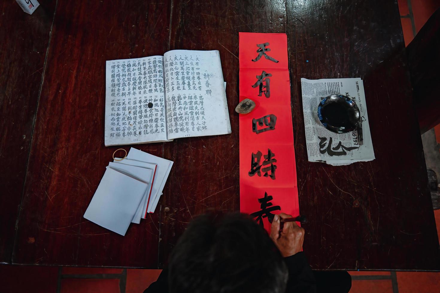 Vietnamese scholar writes calligraphy at Long Son. Calligraphy festival is a popular tradition during Tet holiday. Writing couplets for Spring Festival, new year. photo