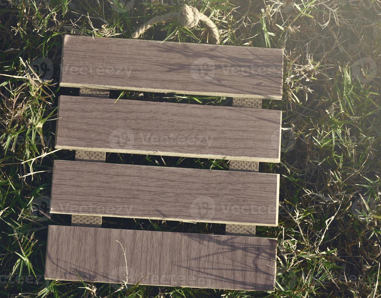 View of empty wooden frame laying on green grass background. Copy space. photo