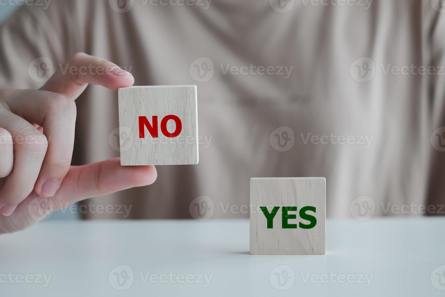 Think With Yes Or No Choice.Test question. Choice hesitate, opposition, opponent view. making decision. Woman hand showing Yes word on wood cube with No text didn't choose stand on table. photo