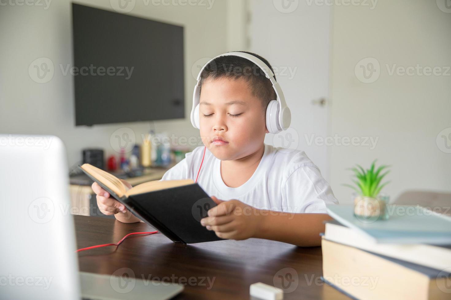 Young student distance learning virtual distance online class on video call virtual lesson, technology studying at home using laptop computer. Parent or tutor teaching child boy with remote education. photo