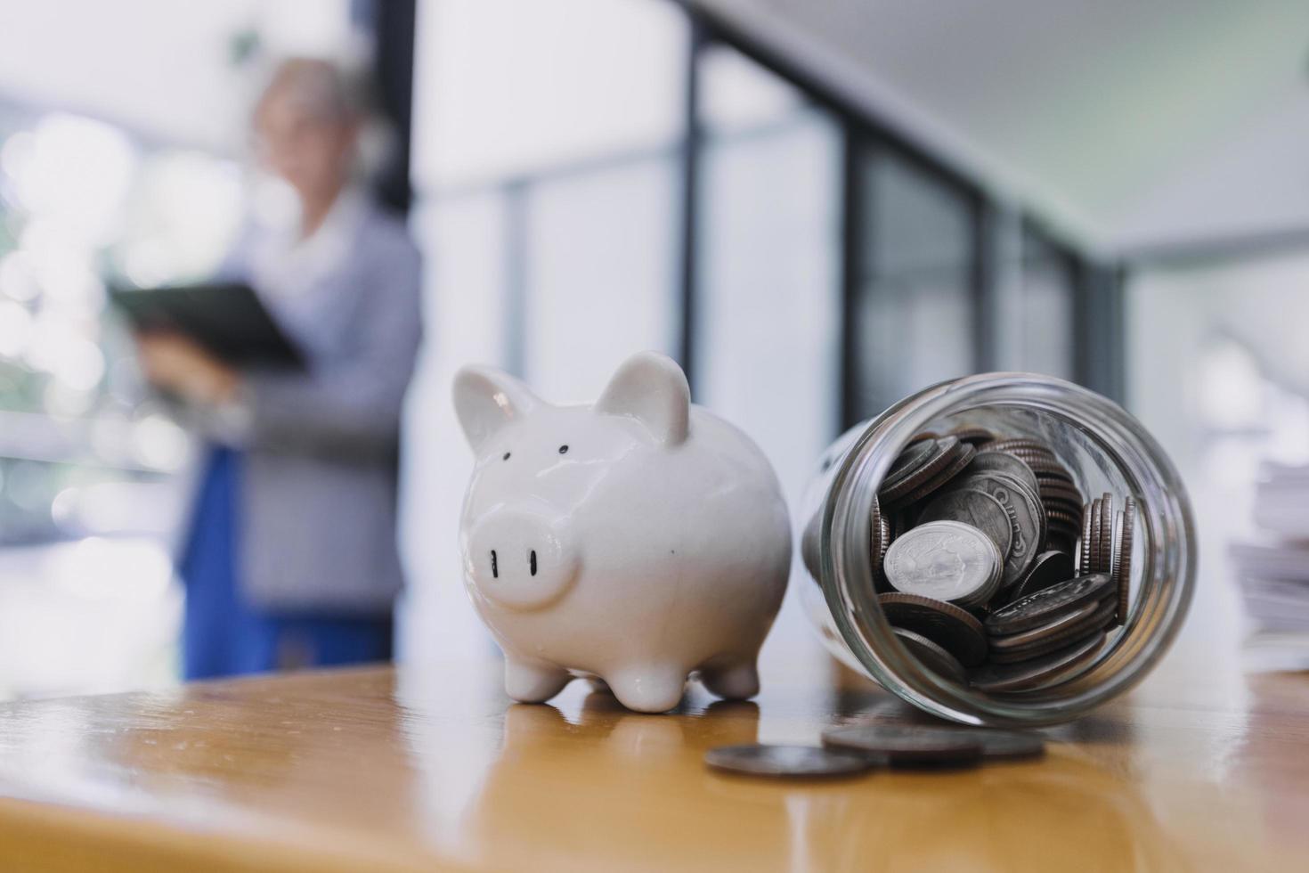 businessman hand putting coin in piggy bank. Saving money concept, business finance and investment. photo