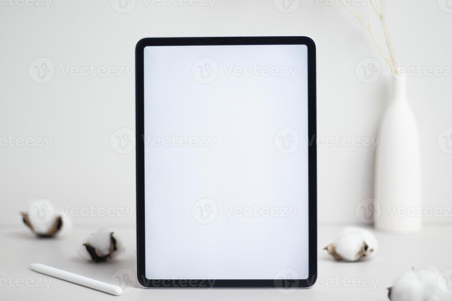 Tablet empty white screen with pencil and cotton flower on white background mockup for design photo