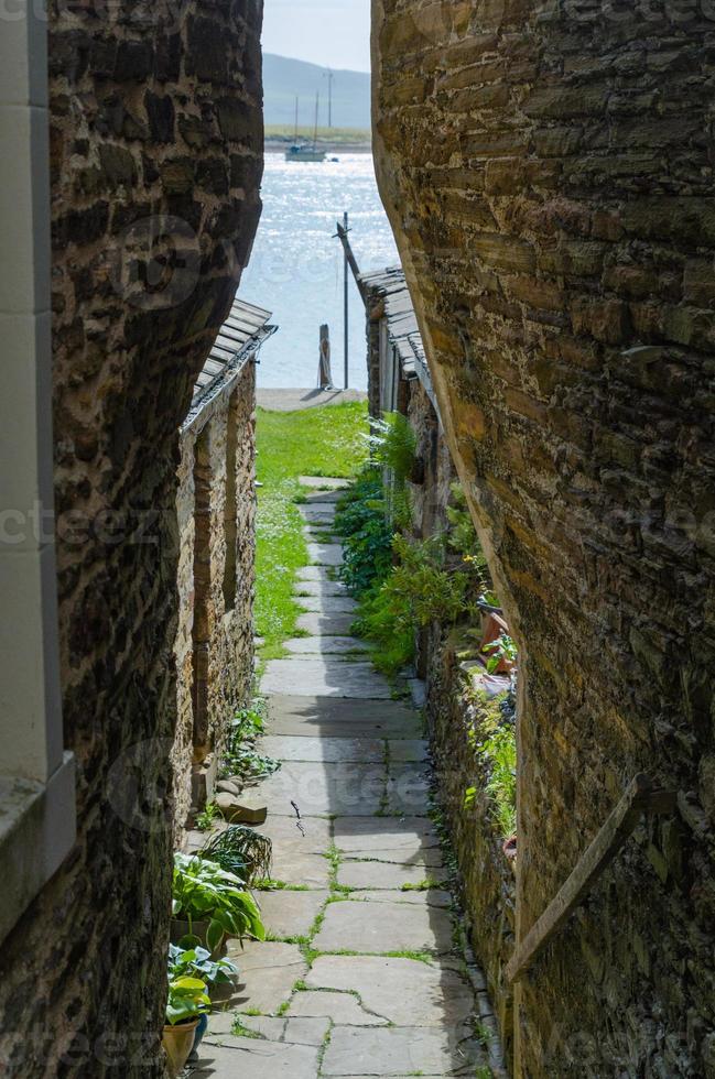 A view of the sea through a narrow alley in Stromness, Orkney. photo