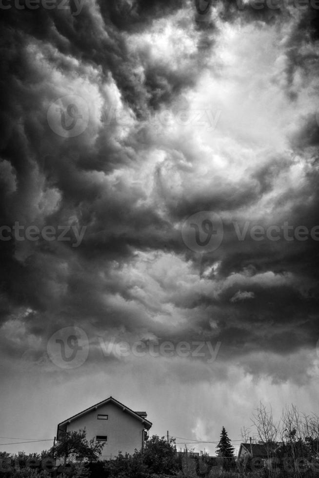 Dark stormy clouds over house photo