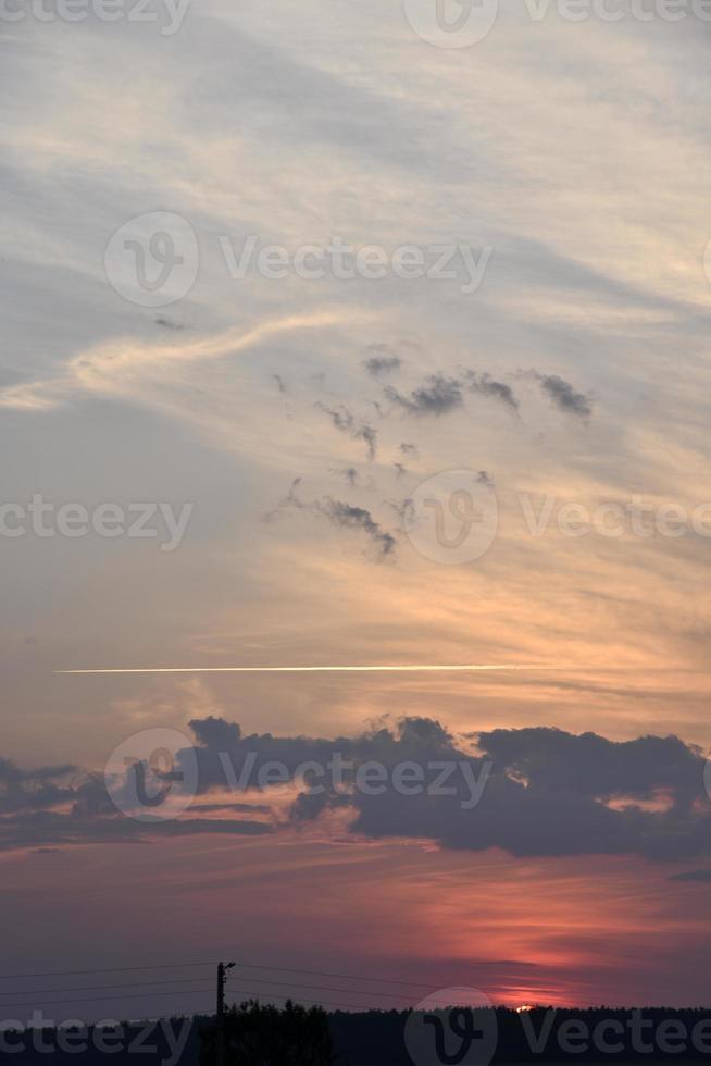 Beautiful sunset summer sky clouds and a flying plane. Sunset evening sky in the evening. photo