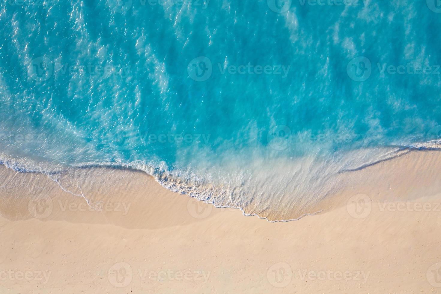 Summer seascape beautiful waves, blue sea water in sunny day. Top view from drone. Sea aerial view, amazing tropical nature background. Beautiful bright sea waves splashing and beach sand sunset light photo