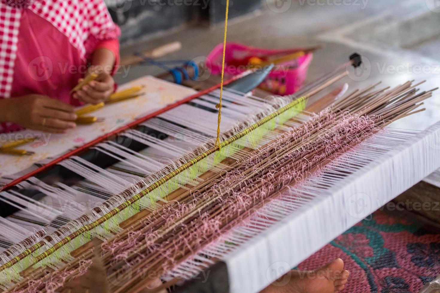 woman hand working at loom close up photo