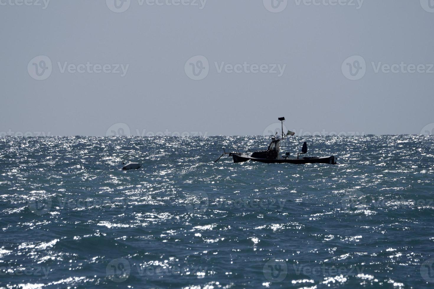 small boat in high waves sea photo
