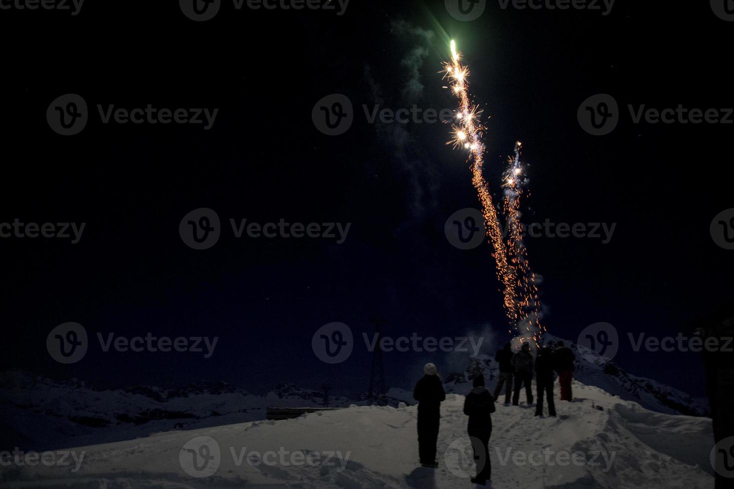 Happy new year and merry xmas fireworks on mountain snow background photo