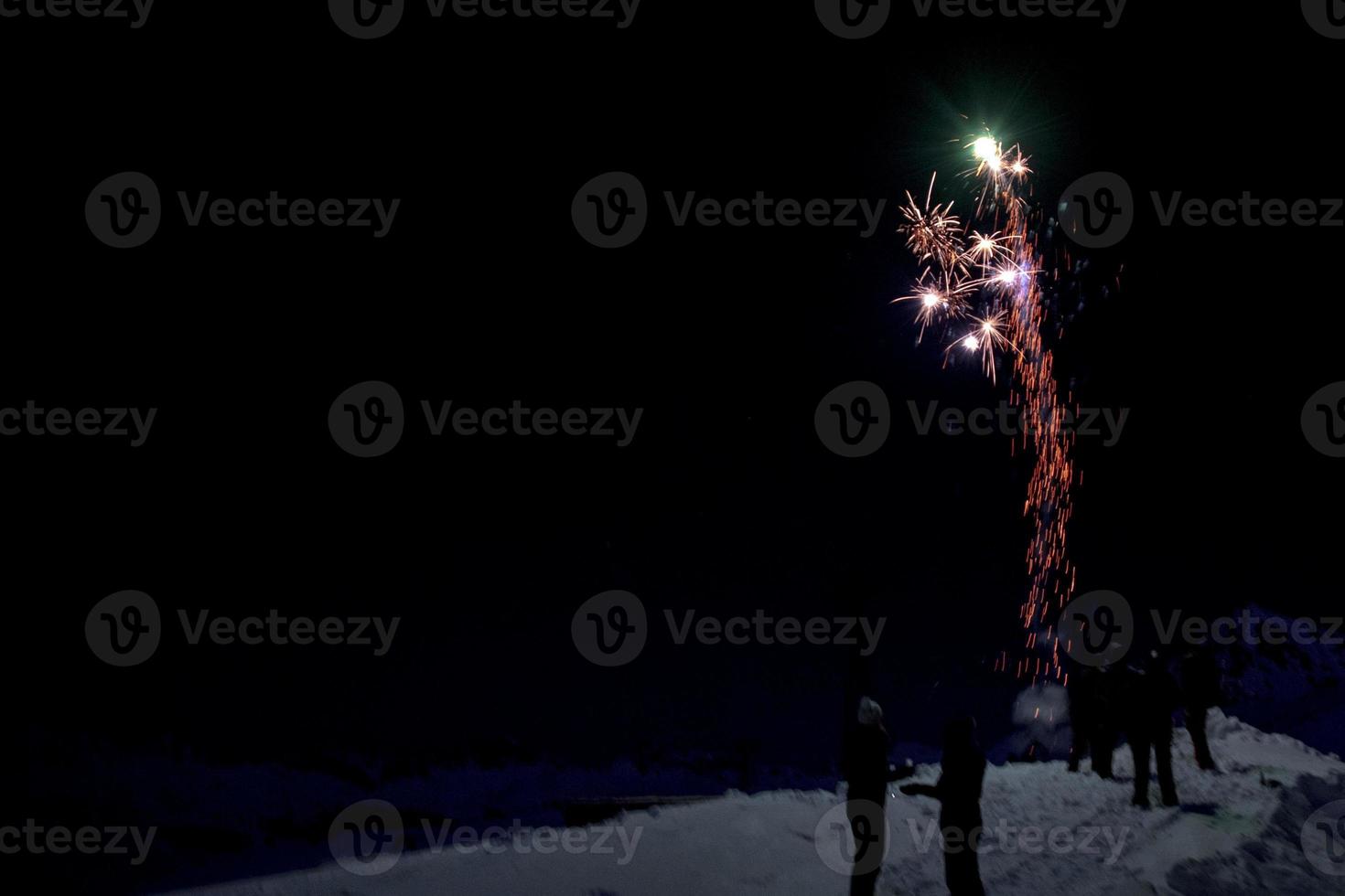 Happy new year and merry xmas fireworks on mountain snow background photo