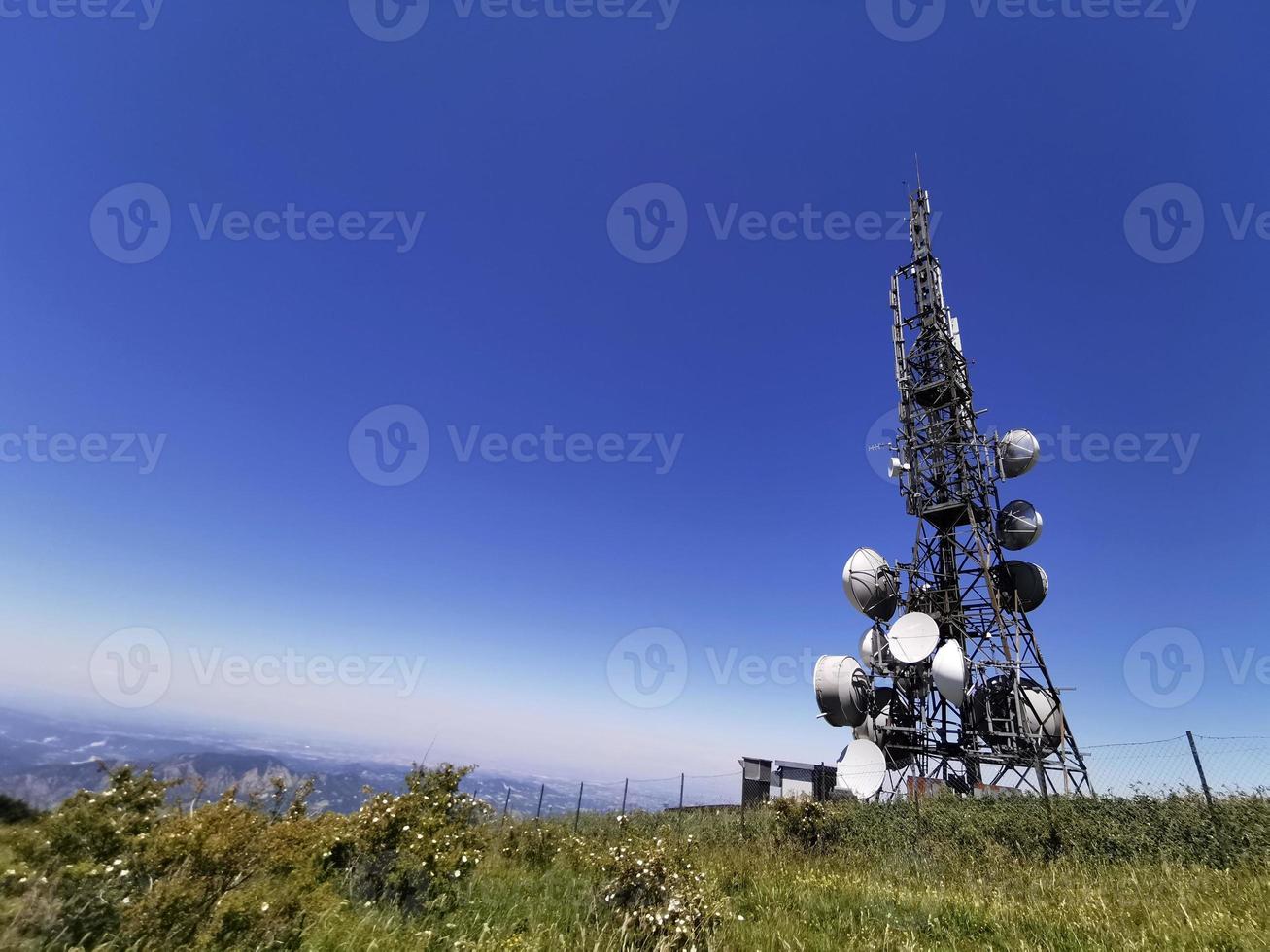 Cellular Communication Antenna tower on blue background photo