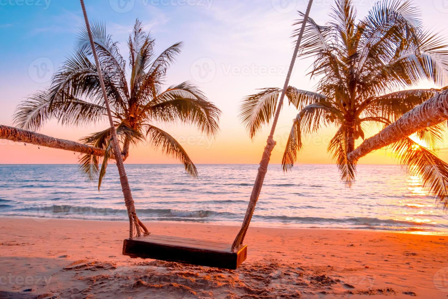 Wood swing beautiful sunset on the sea beach photo