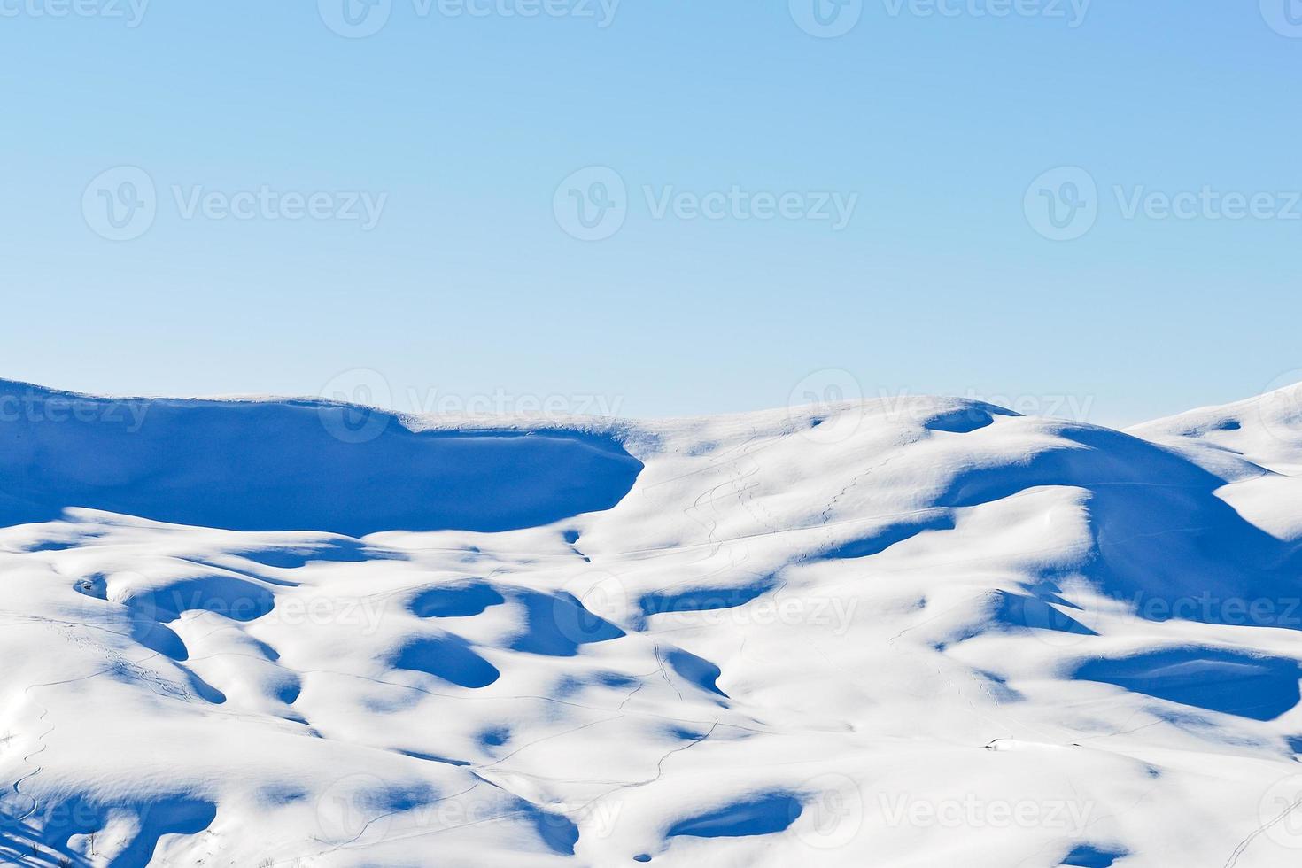 skiing tracks on snow-capped mountains in Alps photo