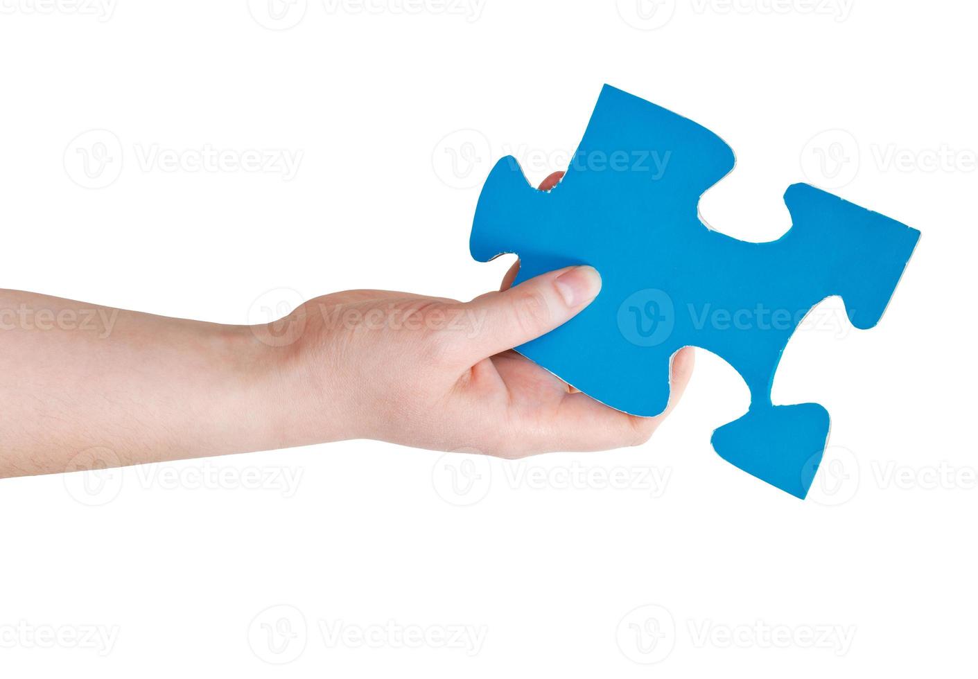 female hand holding big blue paper puzzle piece photo