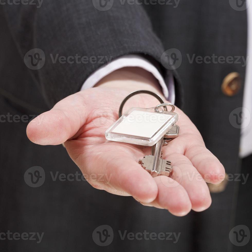 blank door keychain on businessman's palm photo