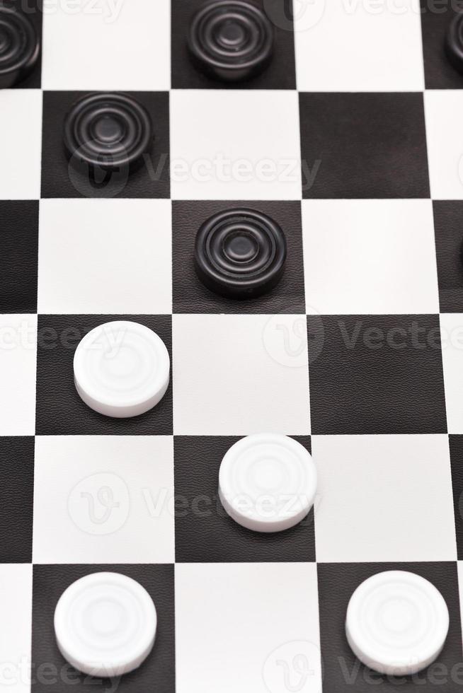 position on black and white draughts board photo