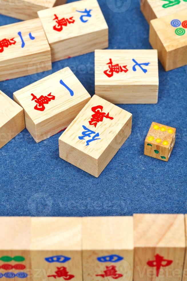 Baldosas de madera en el juego de mahjong en mesa de tela azul foto