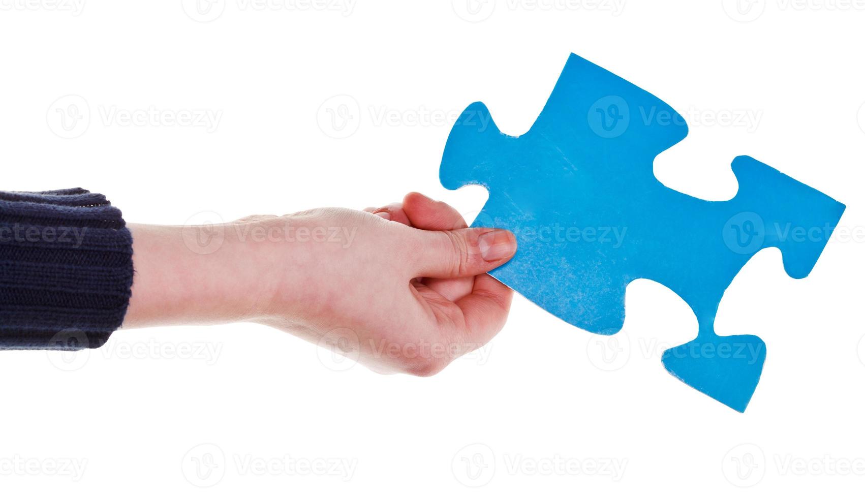 female hand holding big blue paper puzzle piece photo