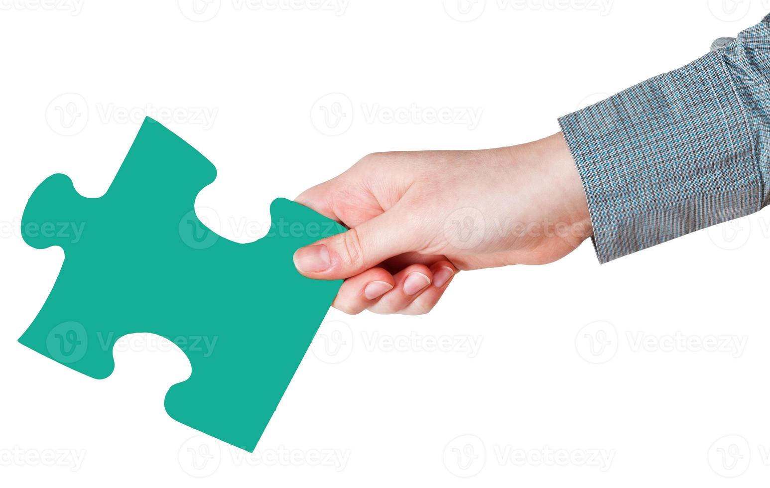 female hand with green puzzle piece photo