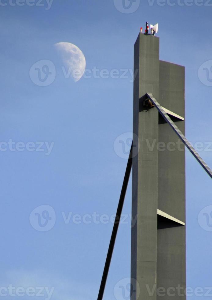 The moon seen next to a bridge in Dusseldorf, Germany photo