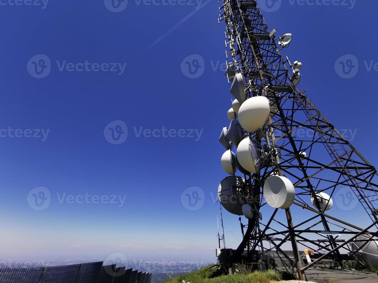 torre de antena de comunicación celular sobre fondo azul foto