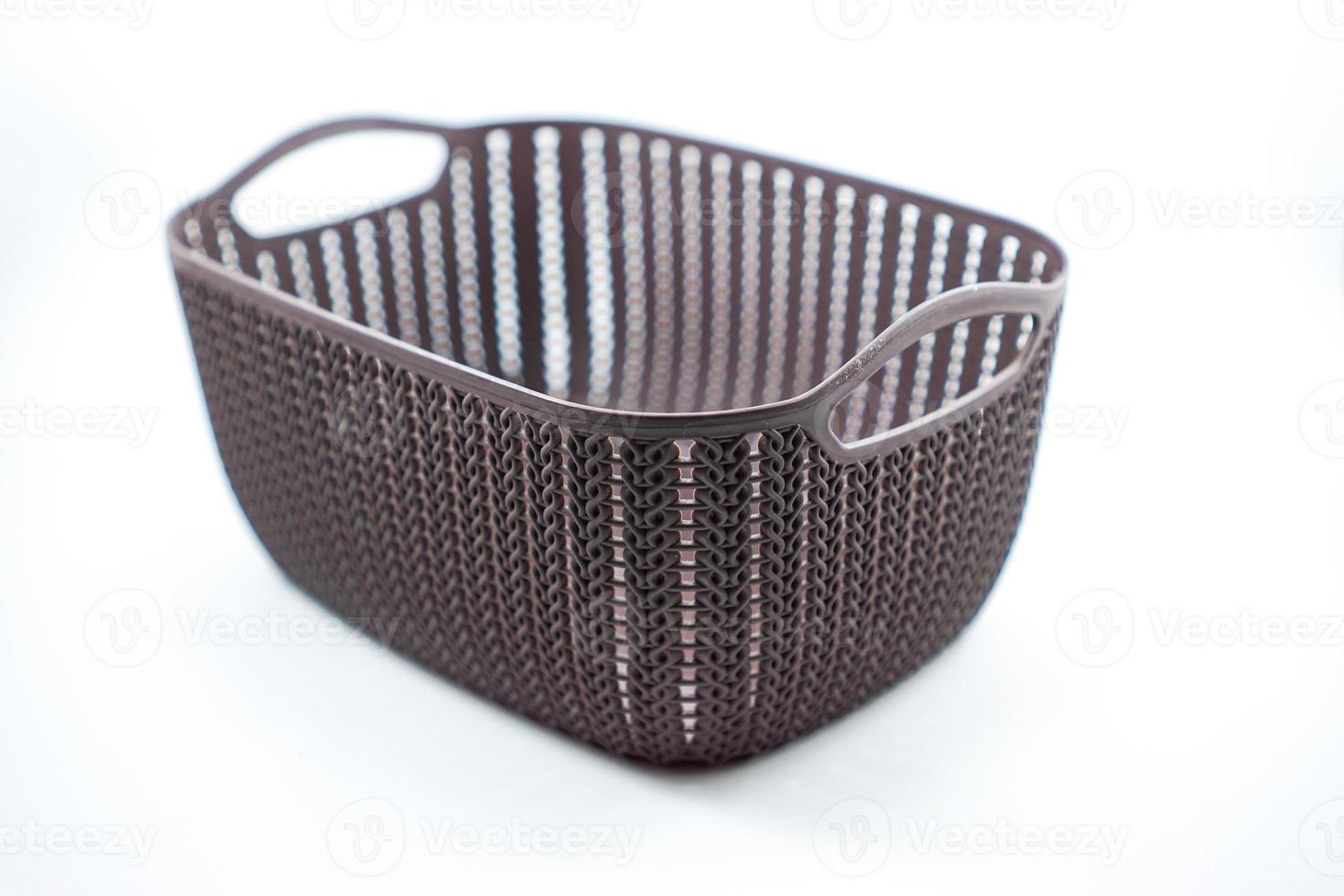 brown plastic basket with woven pattern on a white photo