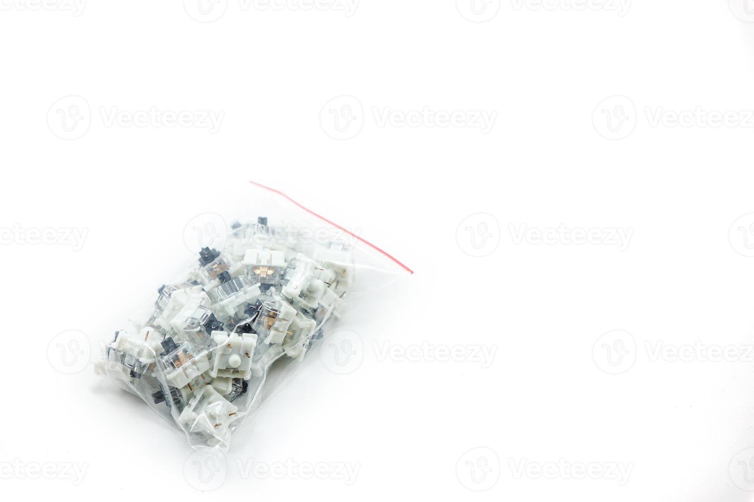 a collection of black mechanical keyboard switch keys wrapped in plastic photo