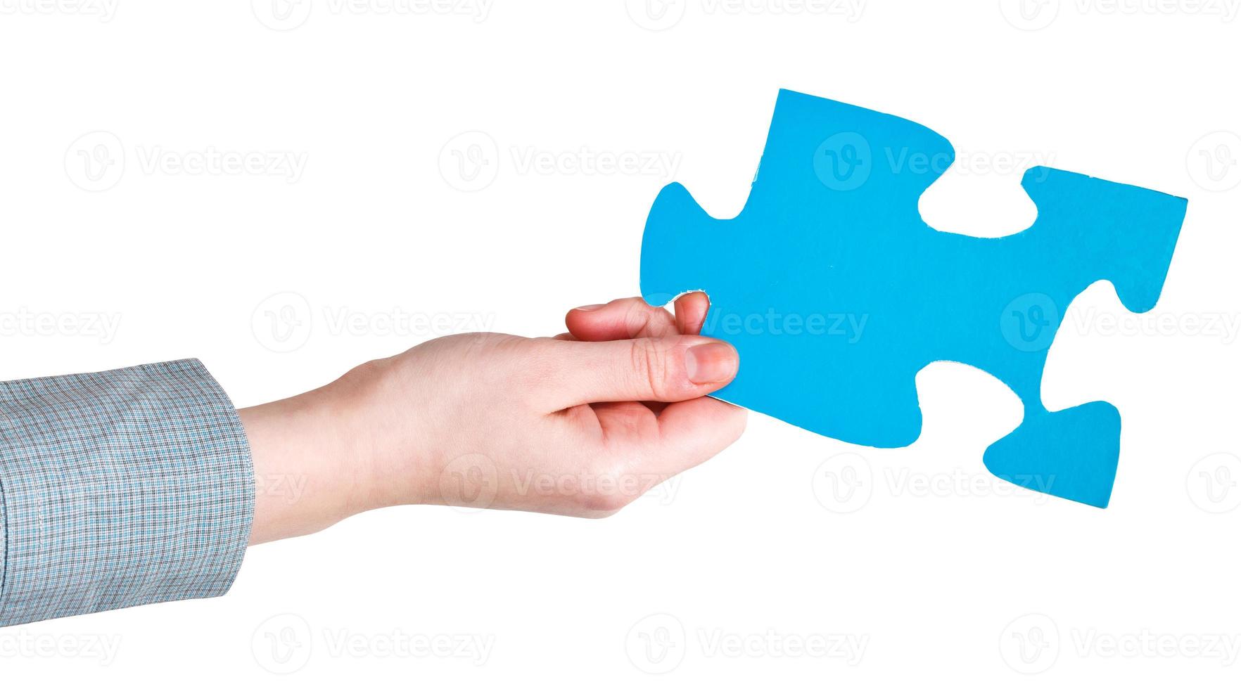 female hand holding big blue paper puzzle piece photo