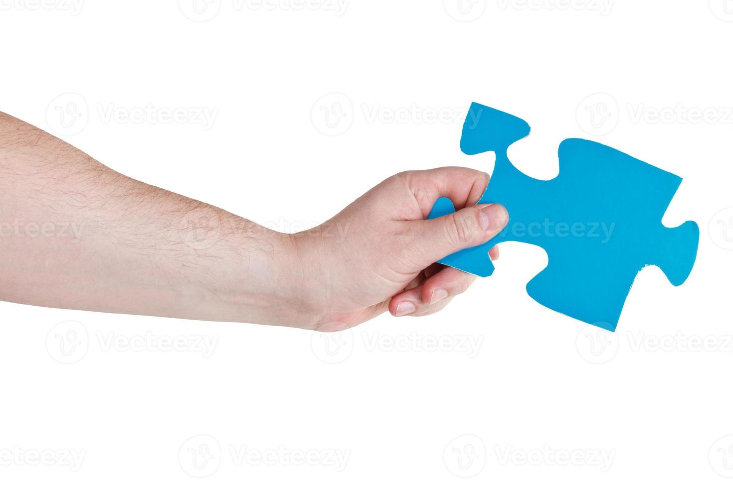 male hand holding big blue paper puzzle piece photo