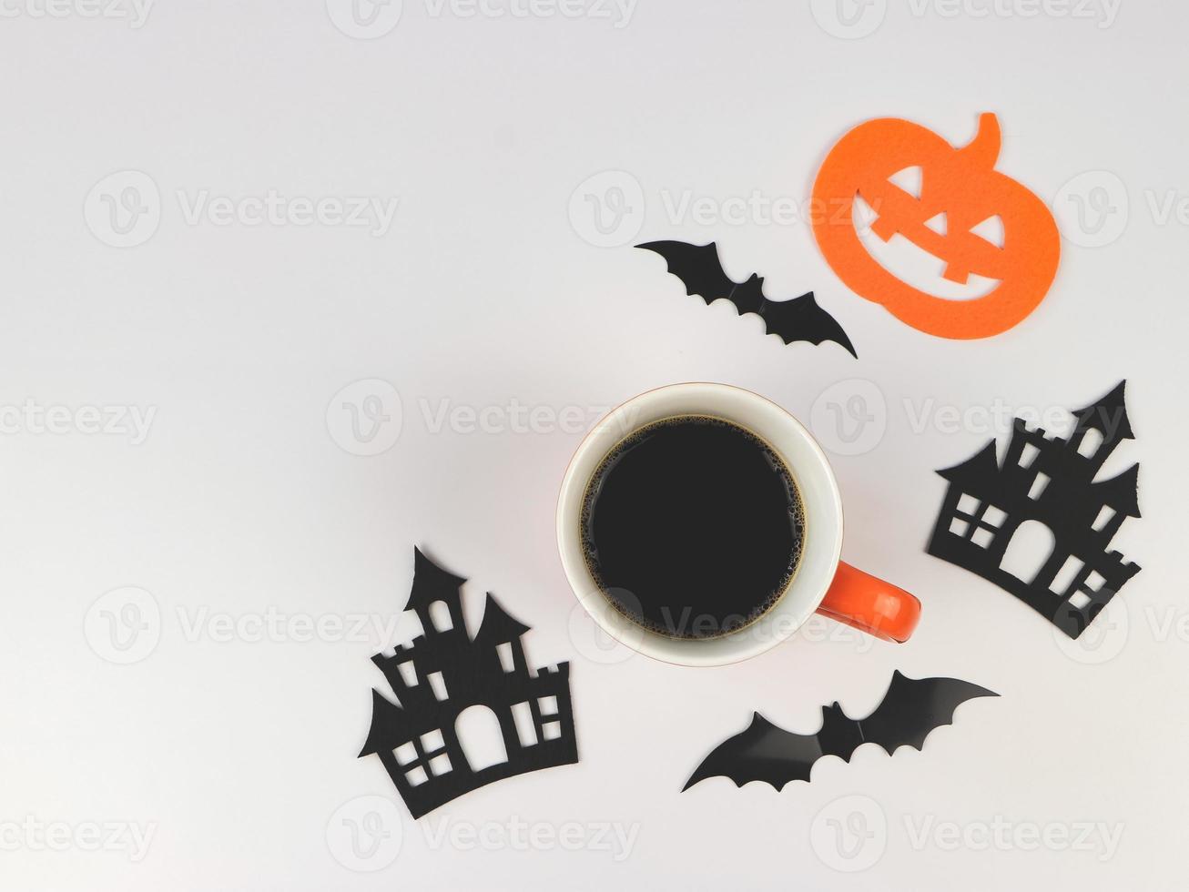 endecha plana de taza naranja de café negro, decoraciones de halloween, castillos, murciélagos y calabaza sobre fondo blanco con espacio para copiar. foto