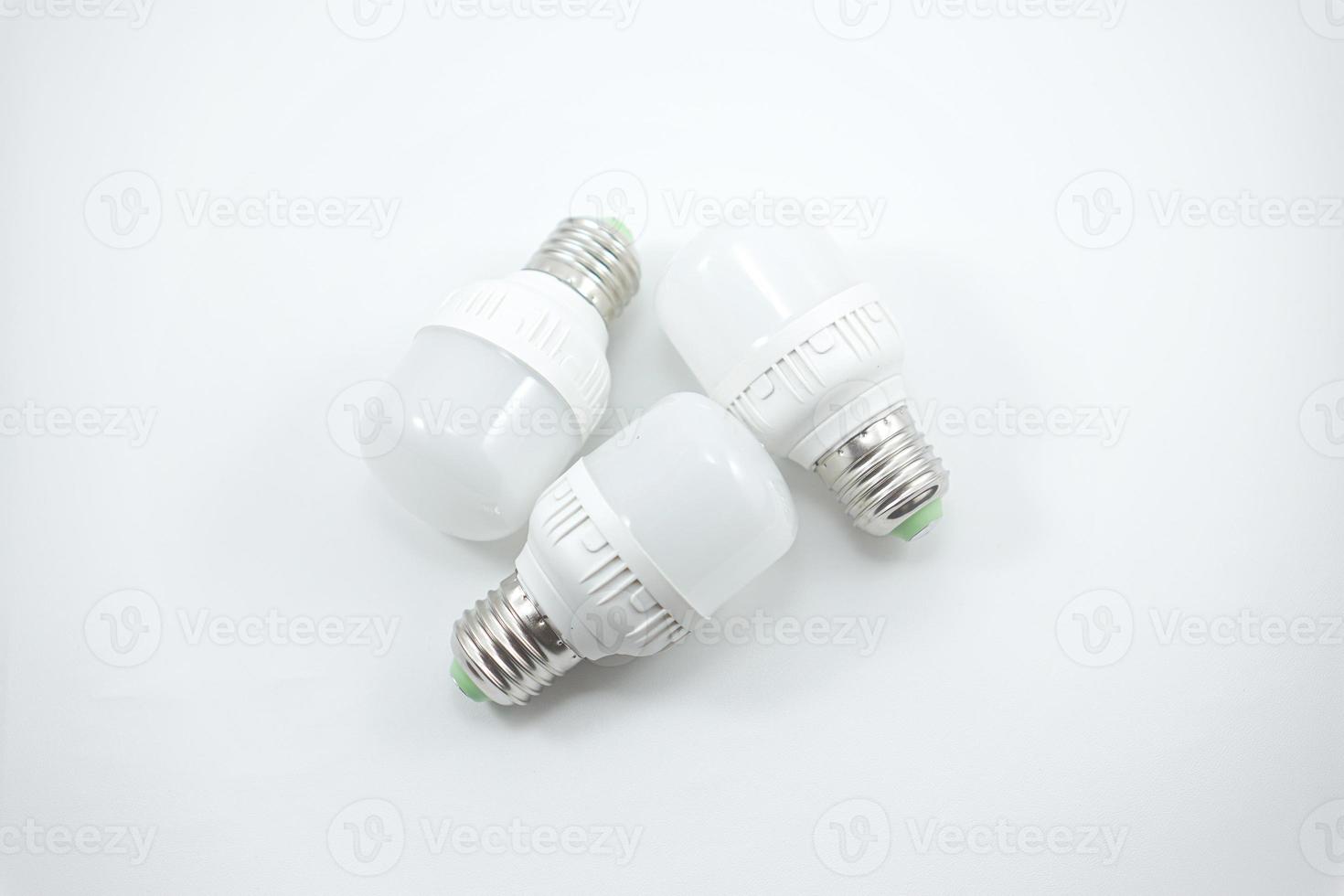 concept of three small white energy-saving light bulbs isolated on a white photo