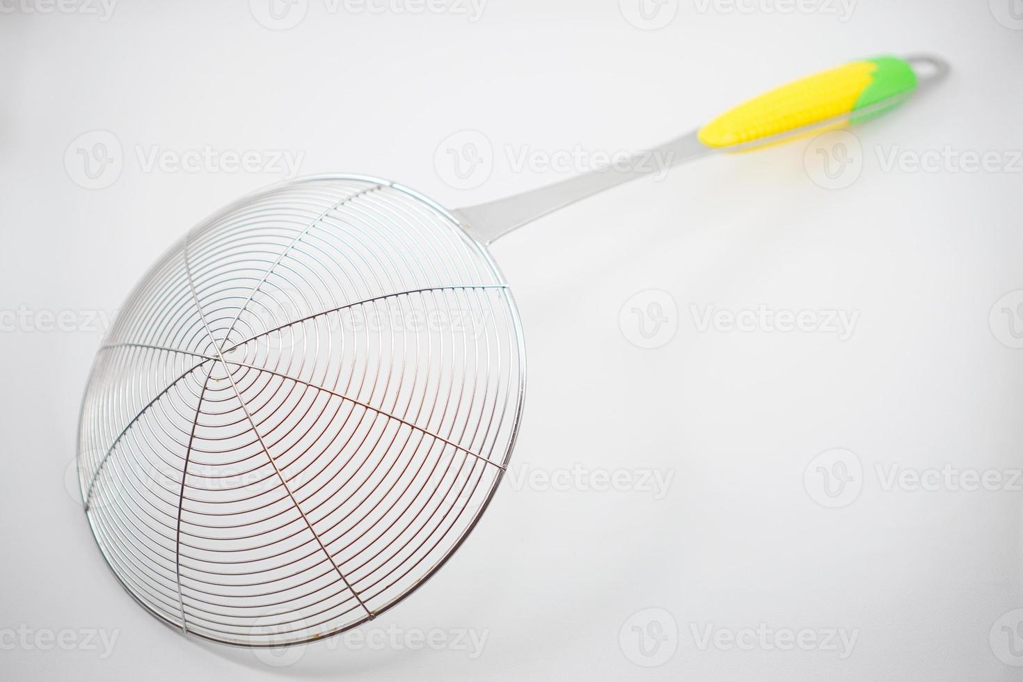 Stainless steel sieve for scooping food from a pan that has hot oil photo