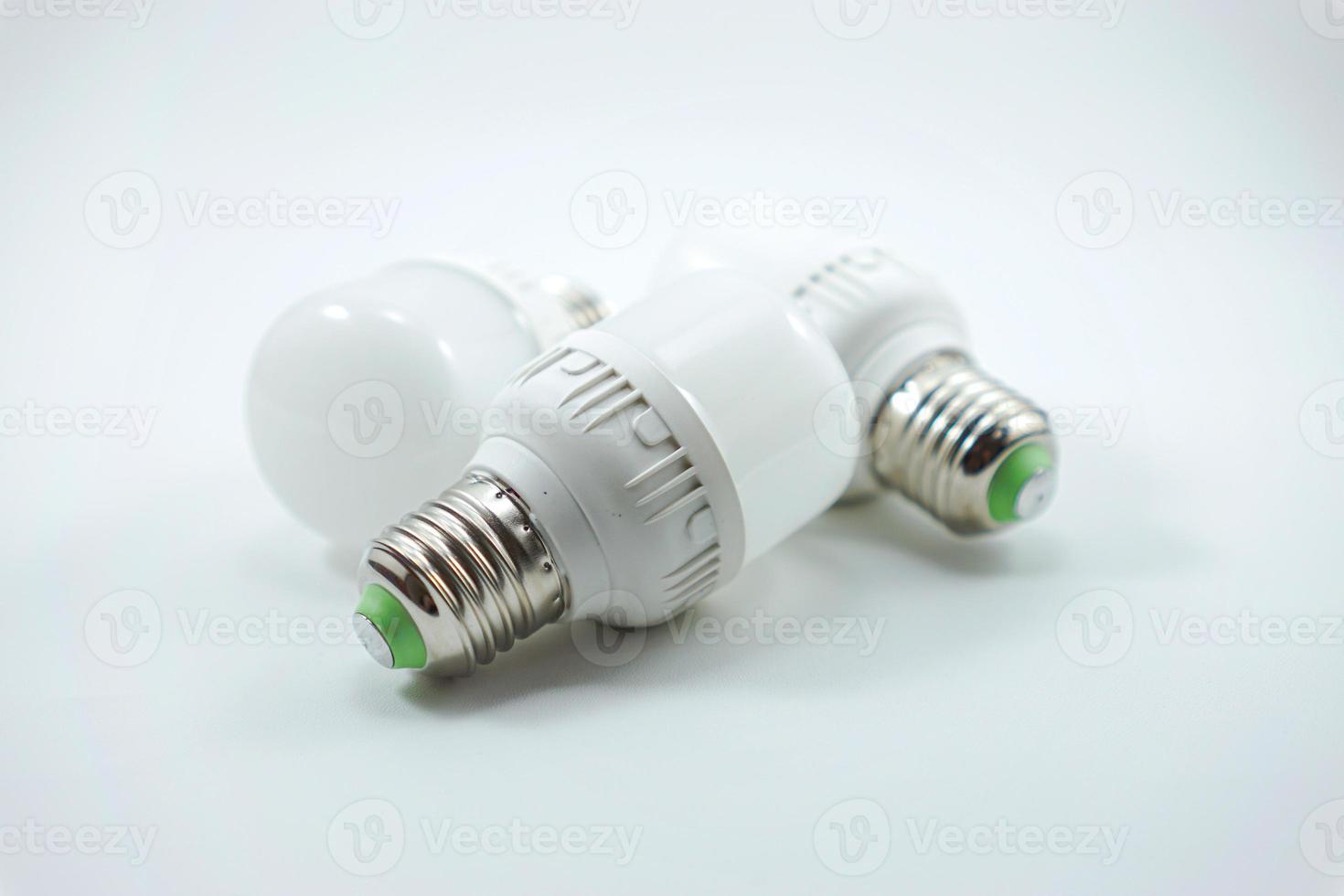 concept of three small white energy-saving light bulbs isolated on a white photo