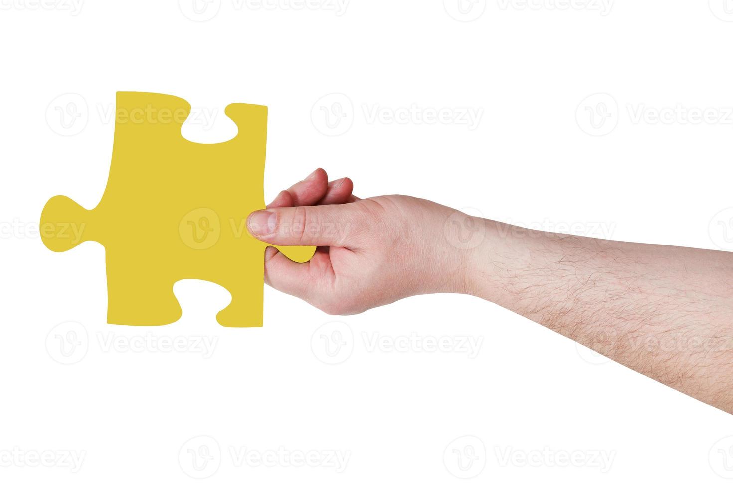 male hand with yellow puzzle piece photo