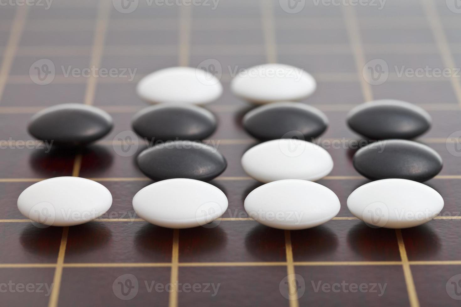 stones during go game playing on wooden board photo