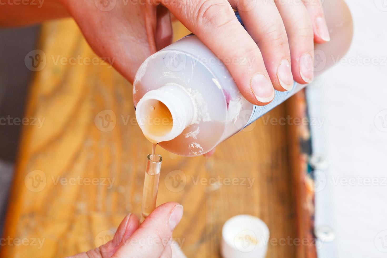 pouring of water based reserve in glass tube photo