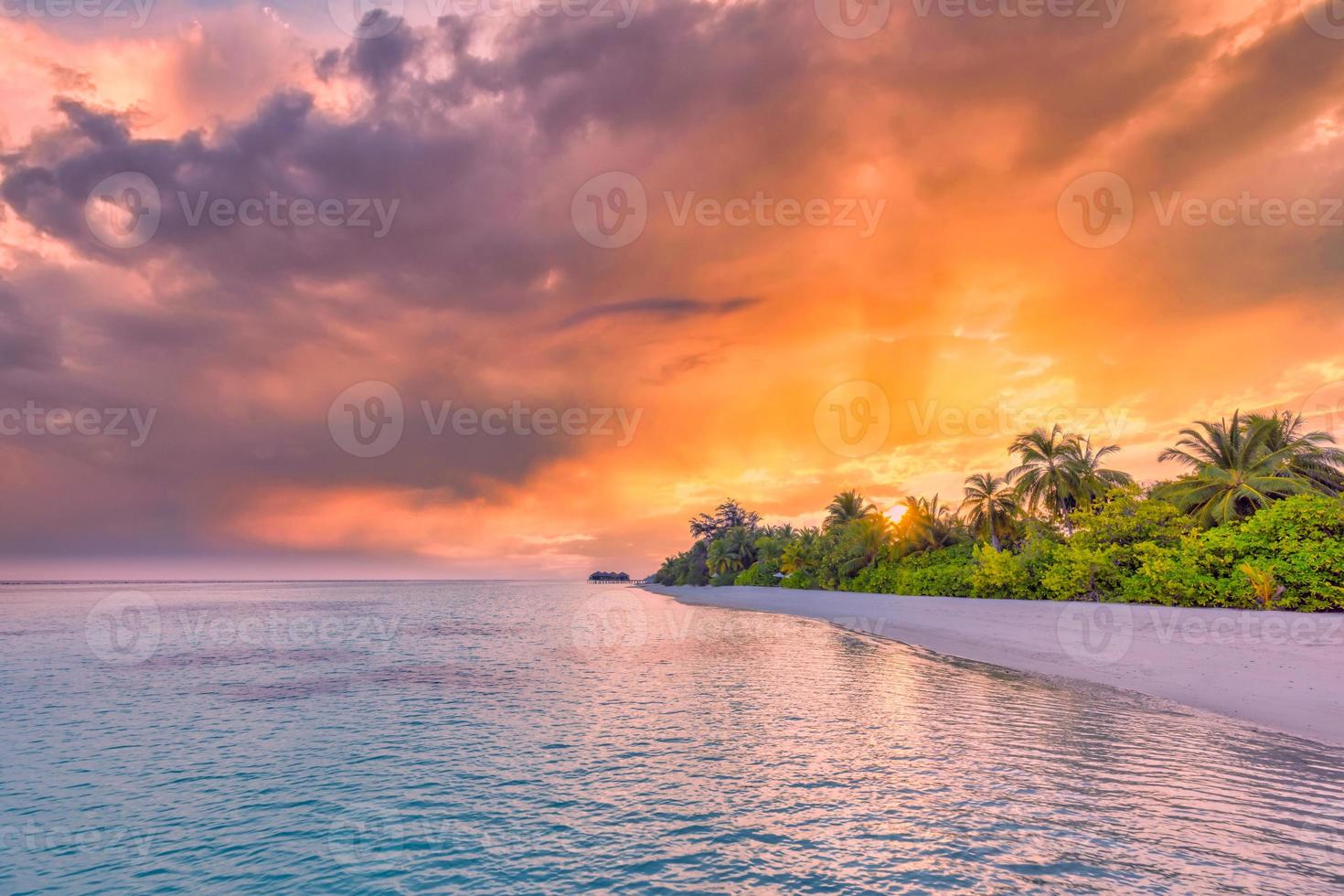 Tranquil summer vacation or holiday landscape. Tropical island sunset beach. Palm trees over calm sea water, sun rays, colorful sky. Exotic nature view, inspirational and peaceful seascape reflection photo