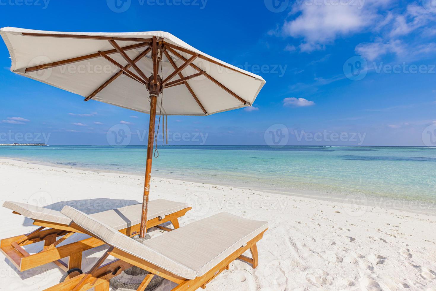 Beautiful tropical island scenery, two sun beds, loungers, umbrella under palm tree. White sand, sea view with horizon, idyllic blue sky, calmness and relaxation. Vacation beach resort hotel traveling photo