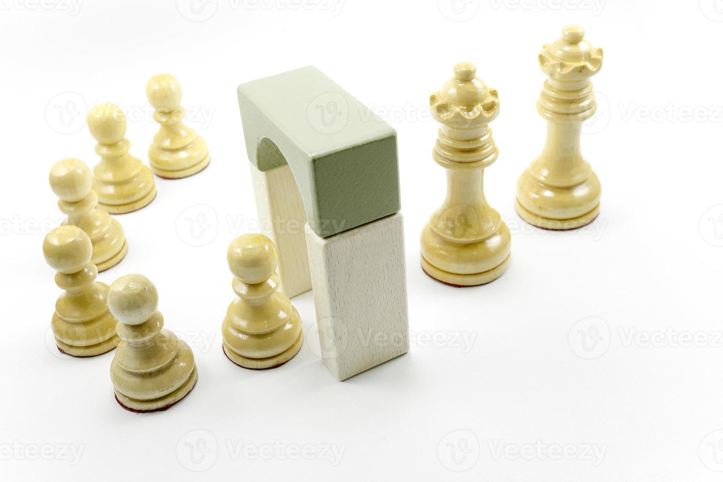 white chess pawns enter the door and exit as queens and kings. photo