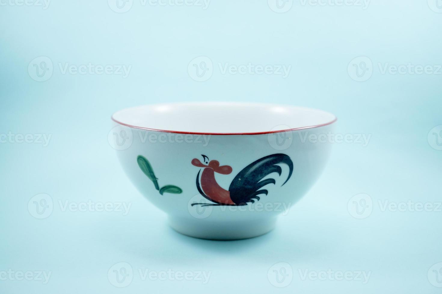 white ceramic bowl with chicken image isolated on turquoise background photo