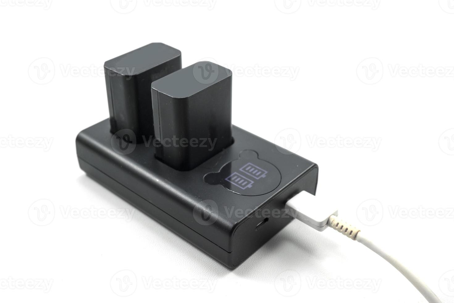 Camera charger with indicator and two batteries isolated on white photo