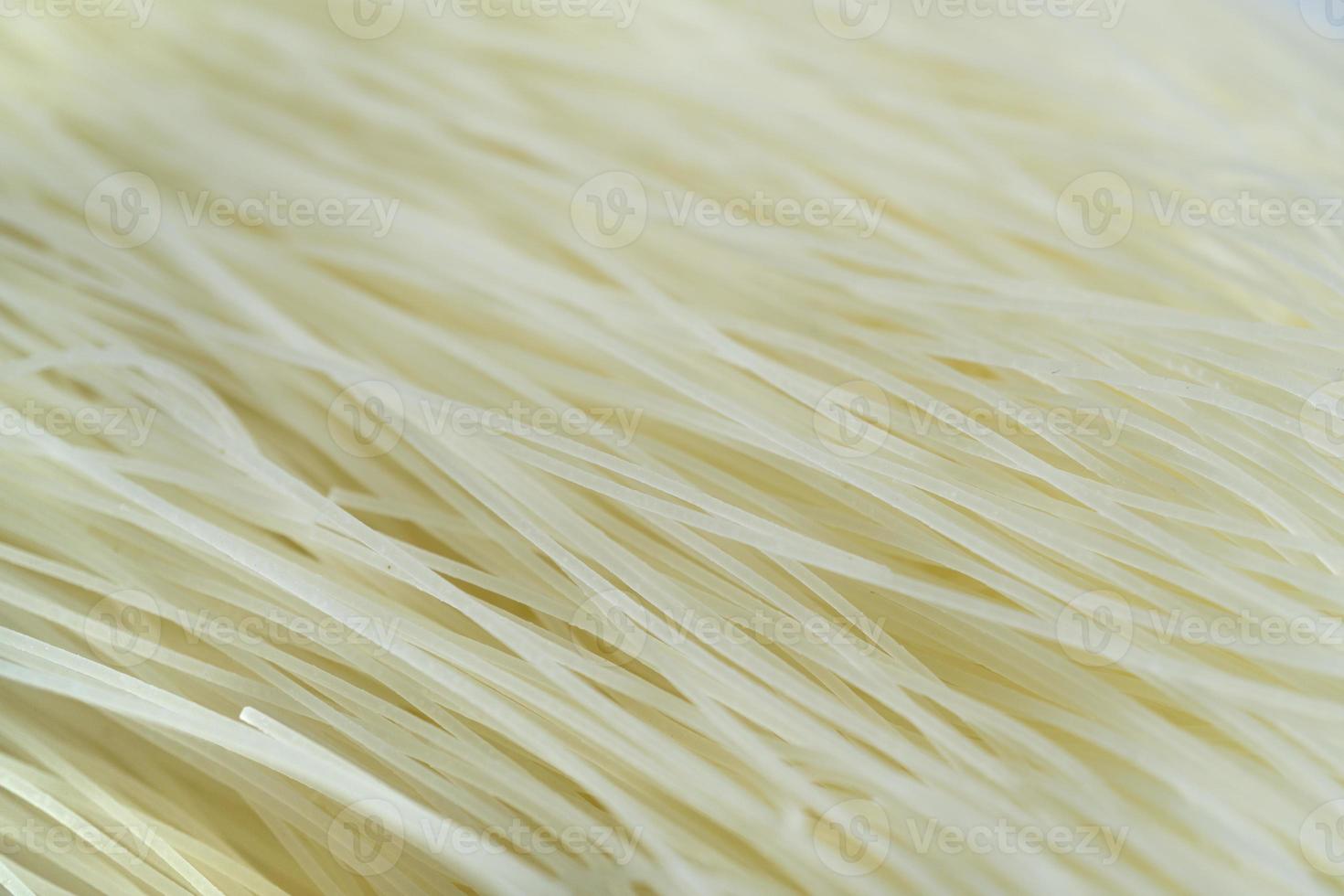 Uncooked and dry rice noodles textured background, food macro close-up photo