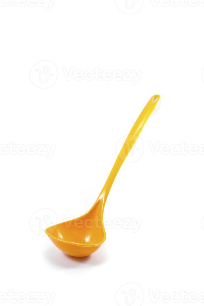 yellow ladle used to scoop soup isolated on a white photo