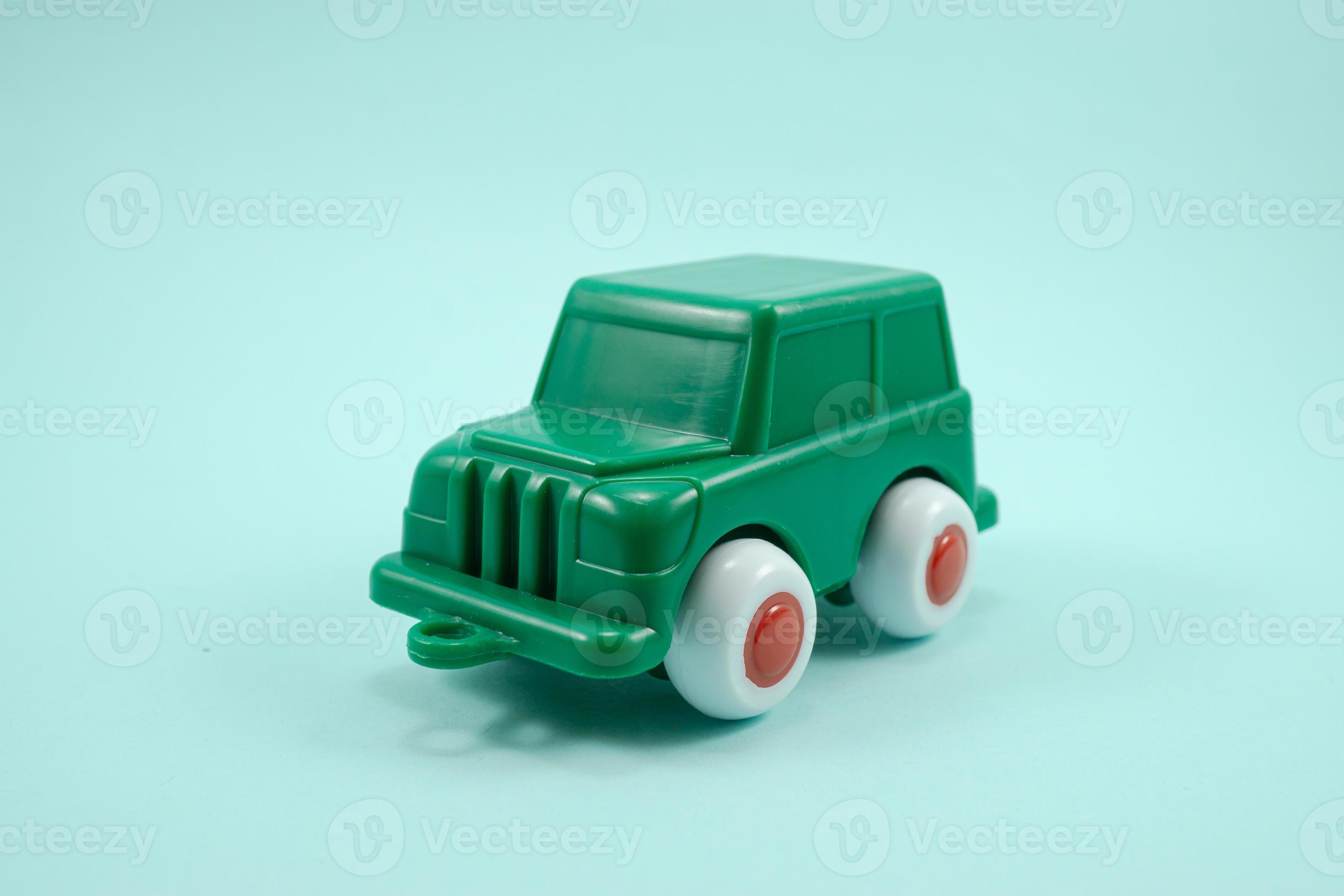 Green paint plastic toy terrain car isolated on turquoise 12053478
