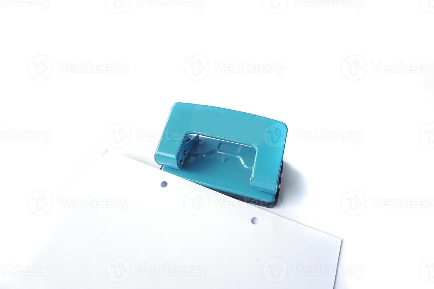 Perforator, blue hole puncher is going to punch the paper isolated on a white photo