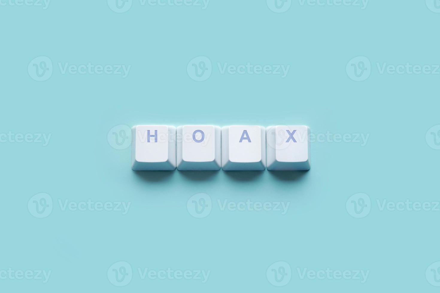 Word HOAX written on computer keyboard keys isolated on a turquoise photo