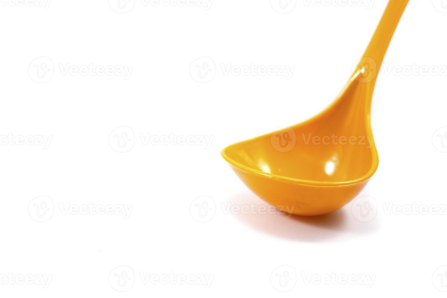 yellow ladle used to scoop soup isolated on a white photo