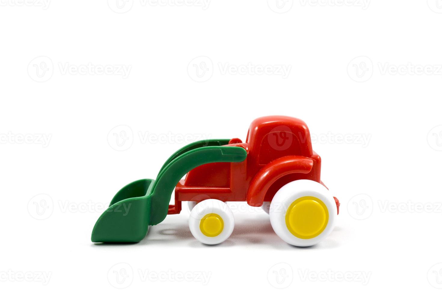 red paint plastic toy bulldozer with green universal blade isolated on white photo