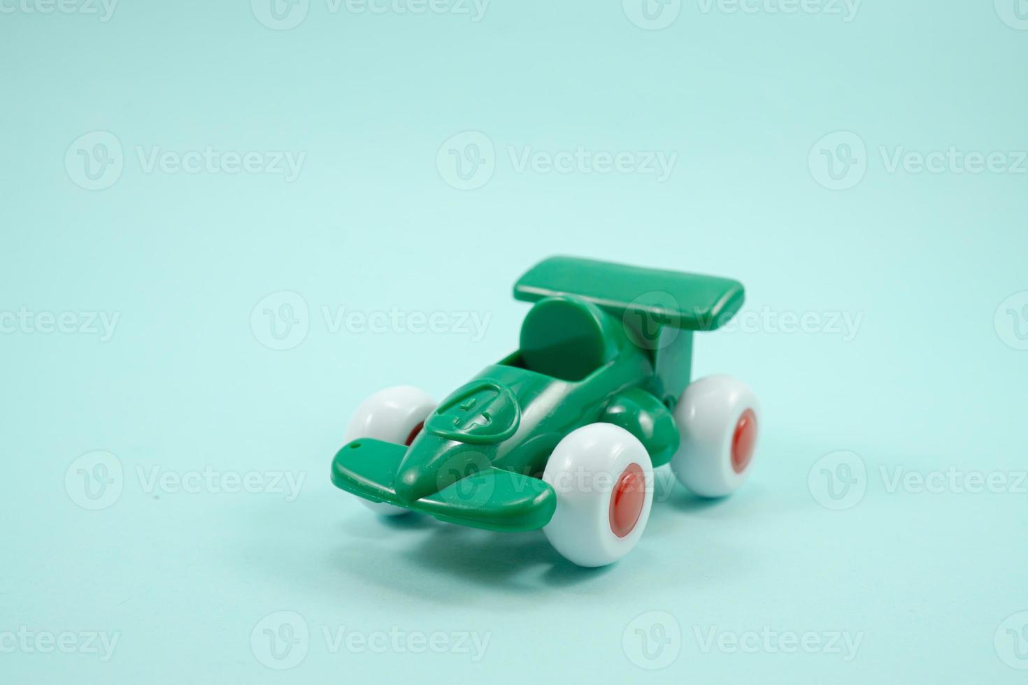 Green paint plastic toy racing car with number one isolated on turquoise photo